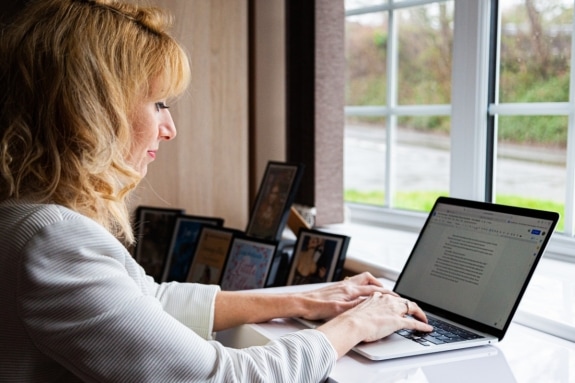 Woman sitting at a desk typing on a laptop