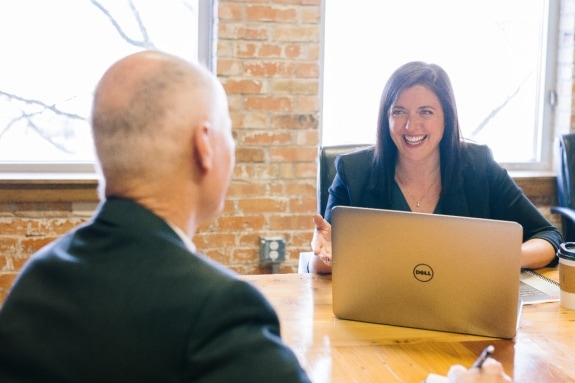 Woman sitting at a desk talking to a man