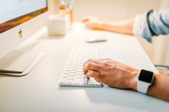 Close-up of person at a desk using a computer