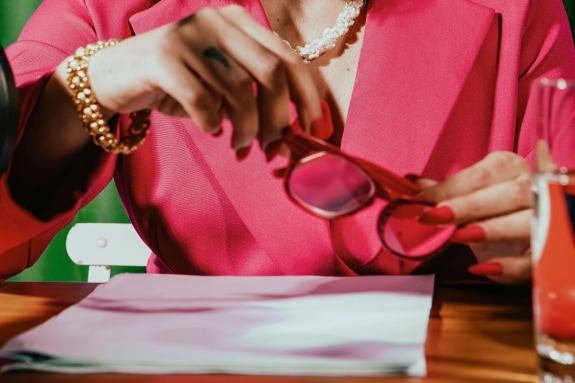 Female holding a pair of reading glasses